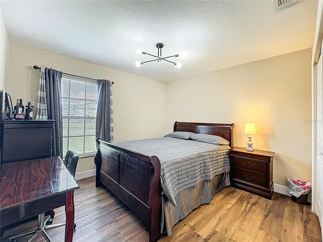 a bedroom with a bed and wooden floor
