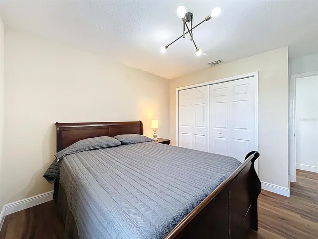 a bedroom with a bed and wooden floor