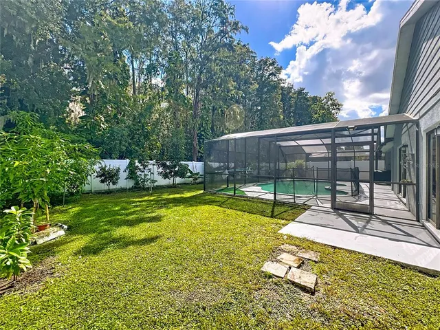 a view of a swimming pool with a patio and a yard