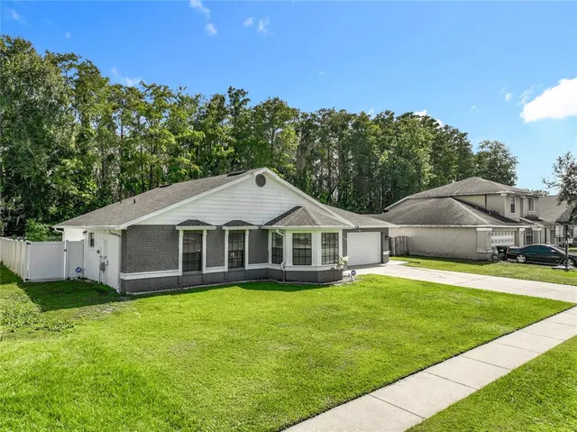 a view of a house with a yard and sitting area