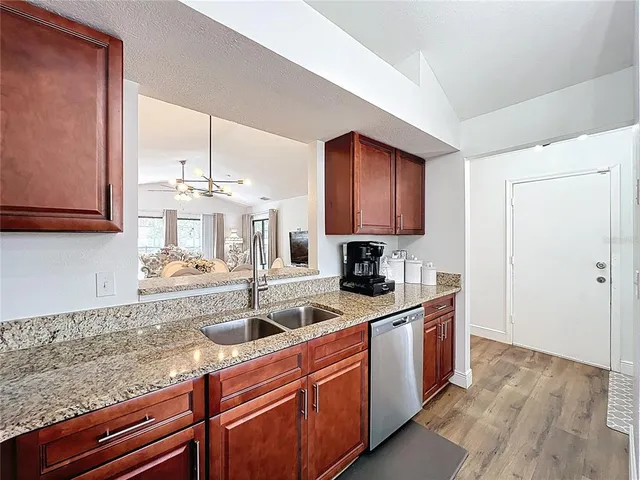 a kitchen with stainless steel appliances granite countertop a sink stove and cabinets