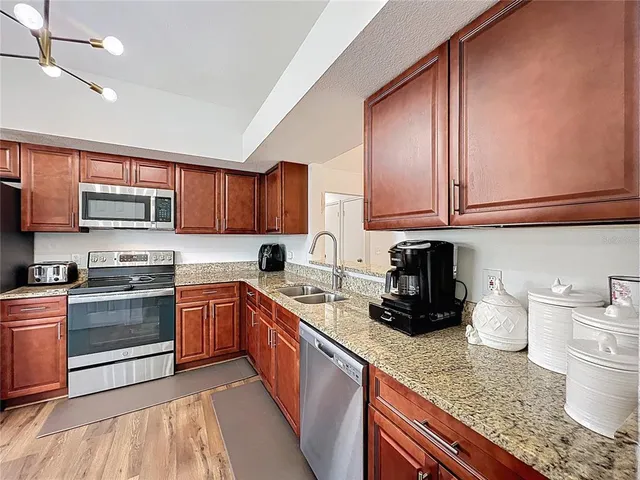 a kitchen with stainless steel appliances granite countertop a sink stove and cabinets