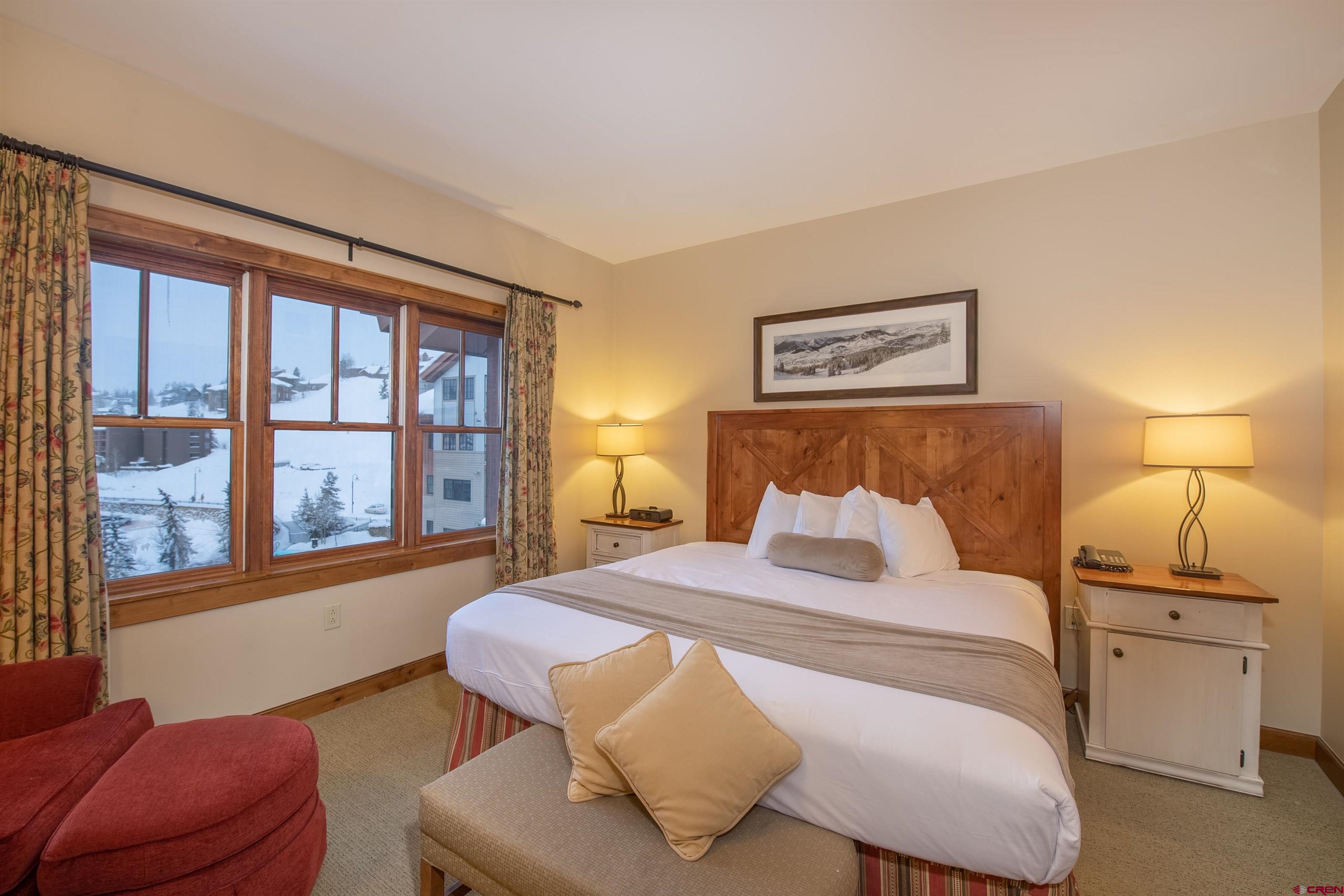 620 Gothic Road, Unit 504 Crested Butte, CO 81225 - Photo 16 of 33 a bedroom with a bed and glass window