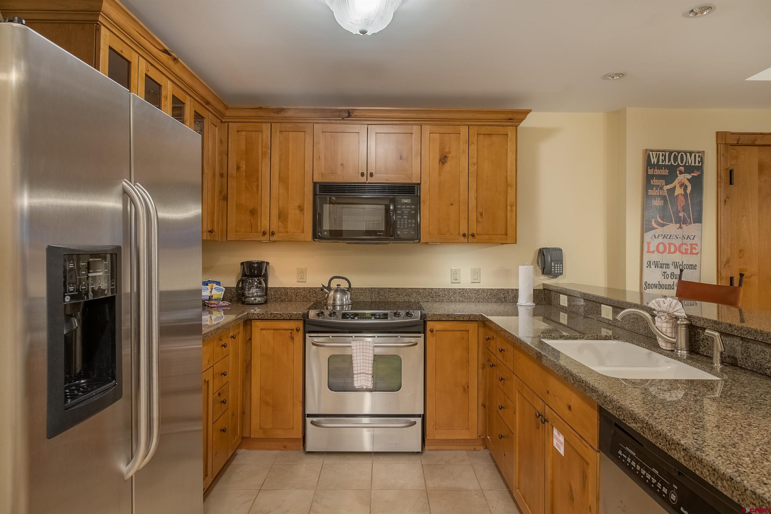 620 Gothic Road, Unit 504 Crested Butte, CO 81225 - Photo 5 of 33 a kitchen with stainless steel appliances granite countertop a sink stove and refrigerator