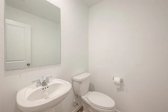 a bathroom with a sink a toilet and mirror