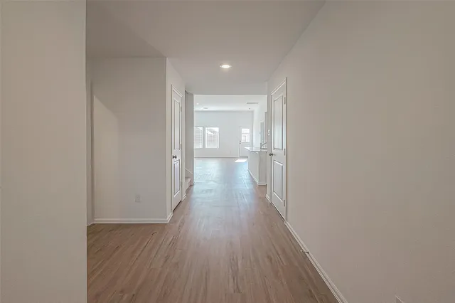 a view of a hallway with wooden floor