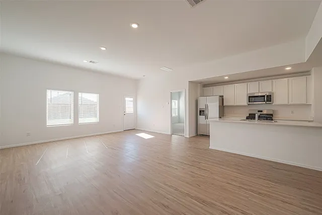 a view of large kitchen with wooden floor and kitchen
