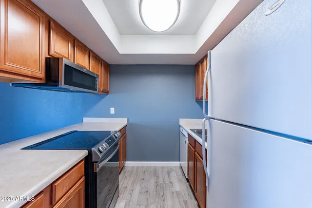 a view of a kitchen with fridge and wooden floor