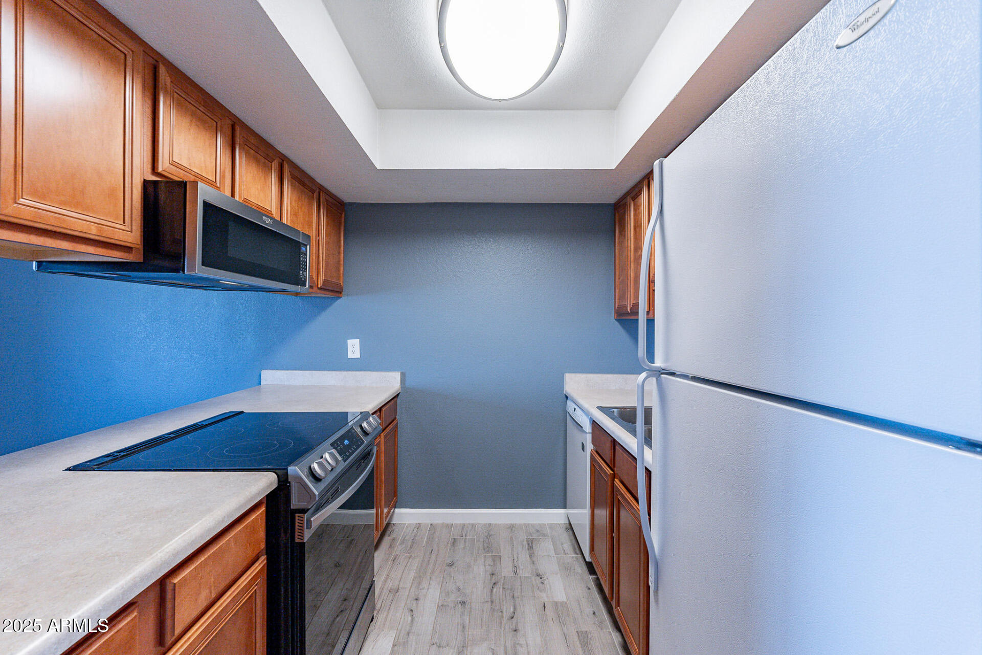 1402 East Guadalupe Road, Unit 207 Tempe, AZ 85283 - Photo 8 of 33 a view of a kitchen with fridge and wooden floor