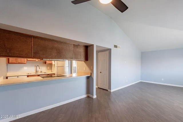 an empty room with a kitchen view