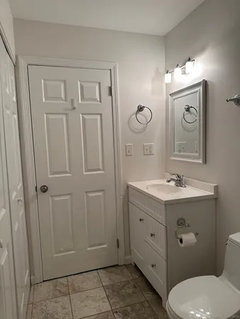 a bathroom with a toilet a sink a mirror a vanity and vanity