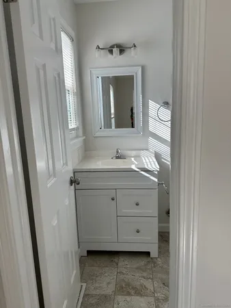 a bathroom with a granite countertop sink and a mirror