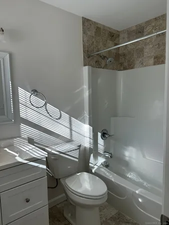a bathroom with a granite countertop toilet sink and shower