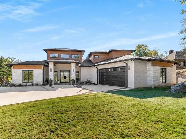a view of a house with a yard and potted plants