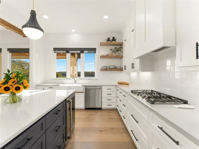 a kitchen with stainless steel appliances a sink stove and cabinets