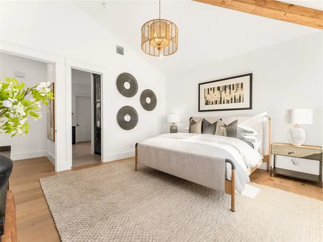 a bedroom with a bed and a chandelier