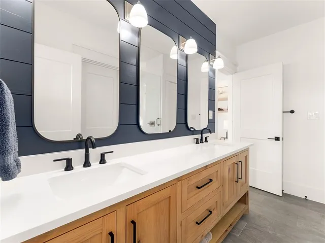 a bathroom with double vanity sinks and a mirror