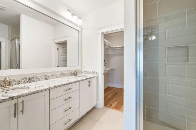 an empty room with wooden floor chandelier fan and windows