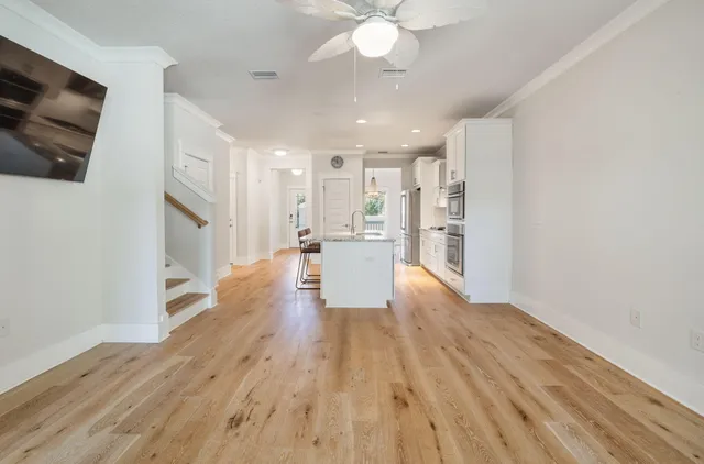 a view of a room with wooden floor and ceiling fan