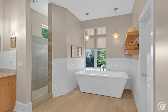 165 East 1550th South Perry, UT 84302 - Photo 19 of 26 Bathroom featuring vanity, tile walls, wood-type flooring, and plus walk in shower