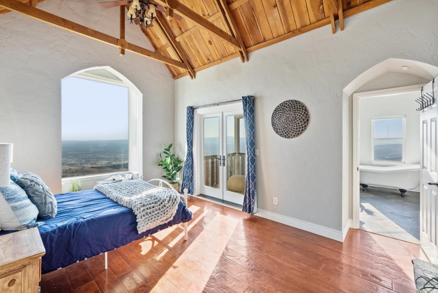 16650 Finley Ridge Road Morgan Hill, CA 95037 - Photo 40 of 85 a spacious bedroom with a bed a mirror and windows