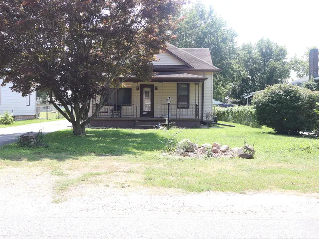 a view of a house with a yard and sitting area