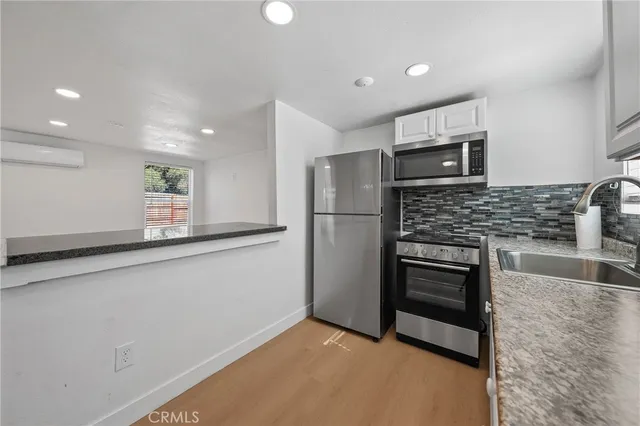 a kitchen with stainless steel appliances a refrigerator and a stove top oven