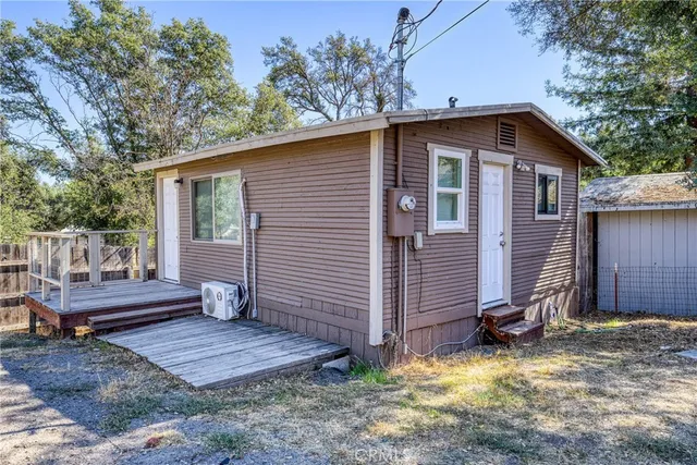 a view of a small house with wooden fence and a yard