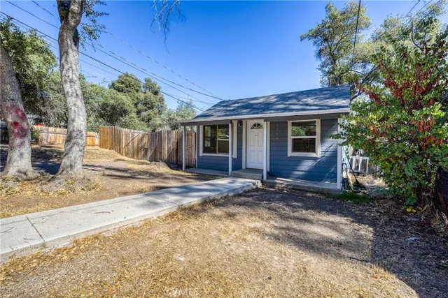a view of a house with a yard and tree