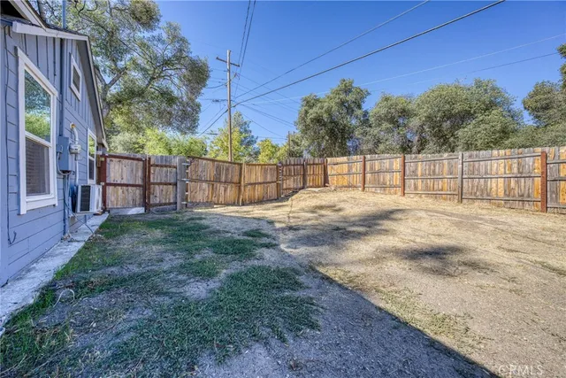 a white house with a small yard and wooden fence