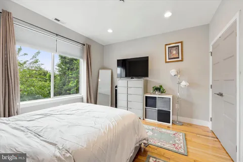 a spacious bedroom with a bed and a flat screen television