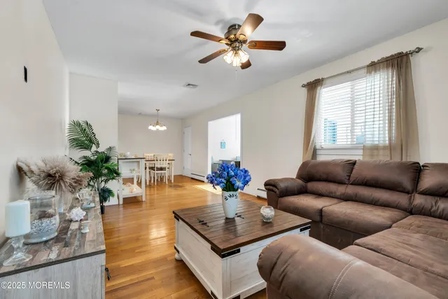 a living room with furniture kitchen view and a chandelier