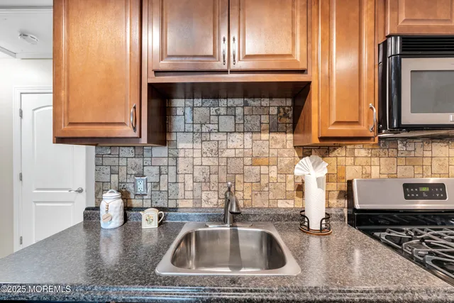 a kitchen with sink a stove and cabinets