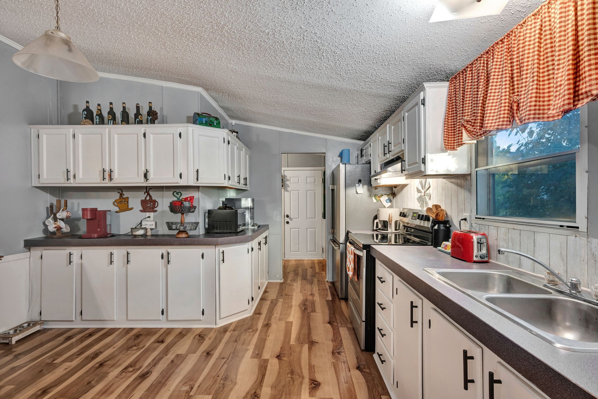 944 Deason Road Dickson, TN 37055 - Photo 12 of 28 a kitchen with granite countertop a sink dishwasher and cabinets with wooden floor