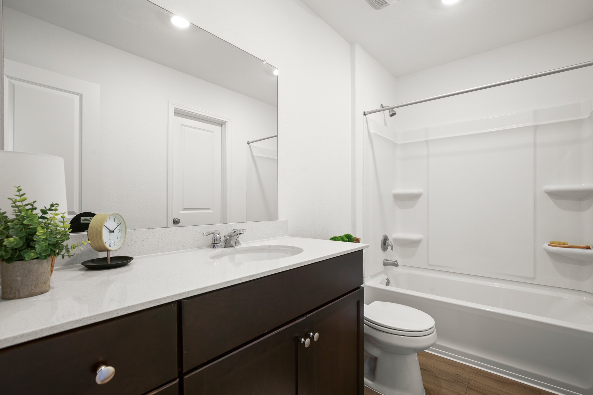 125 Gabbro Gardens Maxwell, TX 78656 - Photo 13 of 24 This lovely primary ensuite bathroom features a spacious vanity with a sleek countertop and a shower/tub combo.