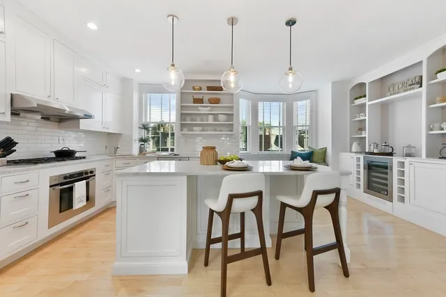 a kitchen with stainless steel appliances kitchen island granite countertop a stove a sink a oven a dining table and chairs