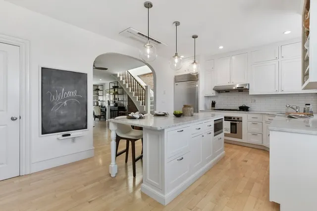 a large kitchen with kitchen island a large counter space a sink appliances and cabinets