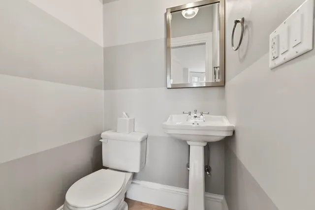 a bathroom with a sink a toilet and mirror