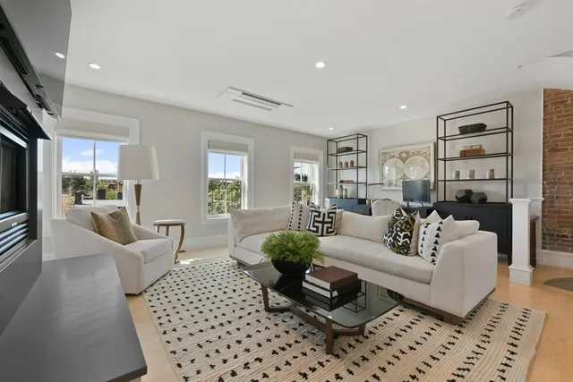a living room with furniture and a large mirror with wooden floor