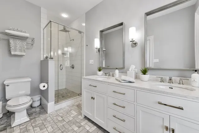 a spacious bathroom with a granite countertop sink toilet a large mirror a shower and a bathtub