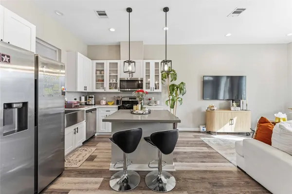 a kitchen with stainless steel appliances kitchen island granite countertop a stove a sink and a refrigerator