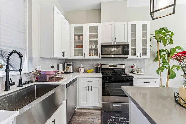 a kitchen with stainless steel appliances granite countertop a stove a sink and a microwave