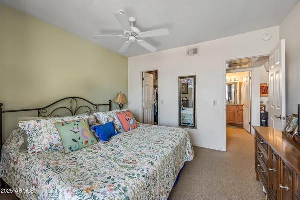 a bedroom with a large bed and a chandelier