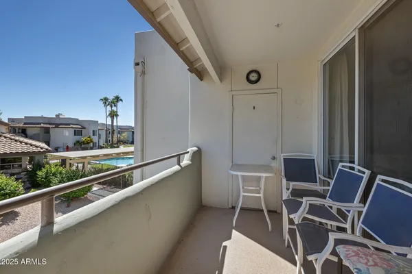 a balcony with table and chairs