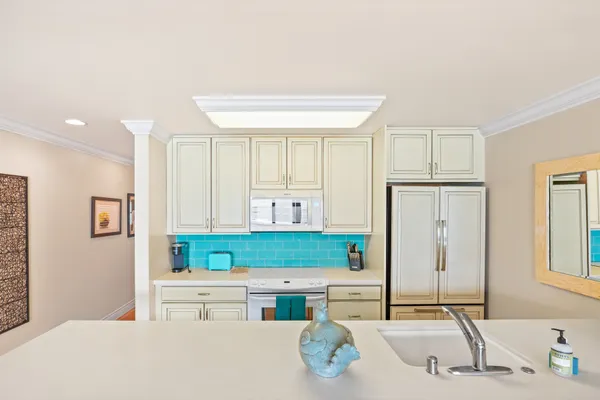 a kitchen with kitchen island a stove a sink and a refrigerator
