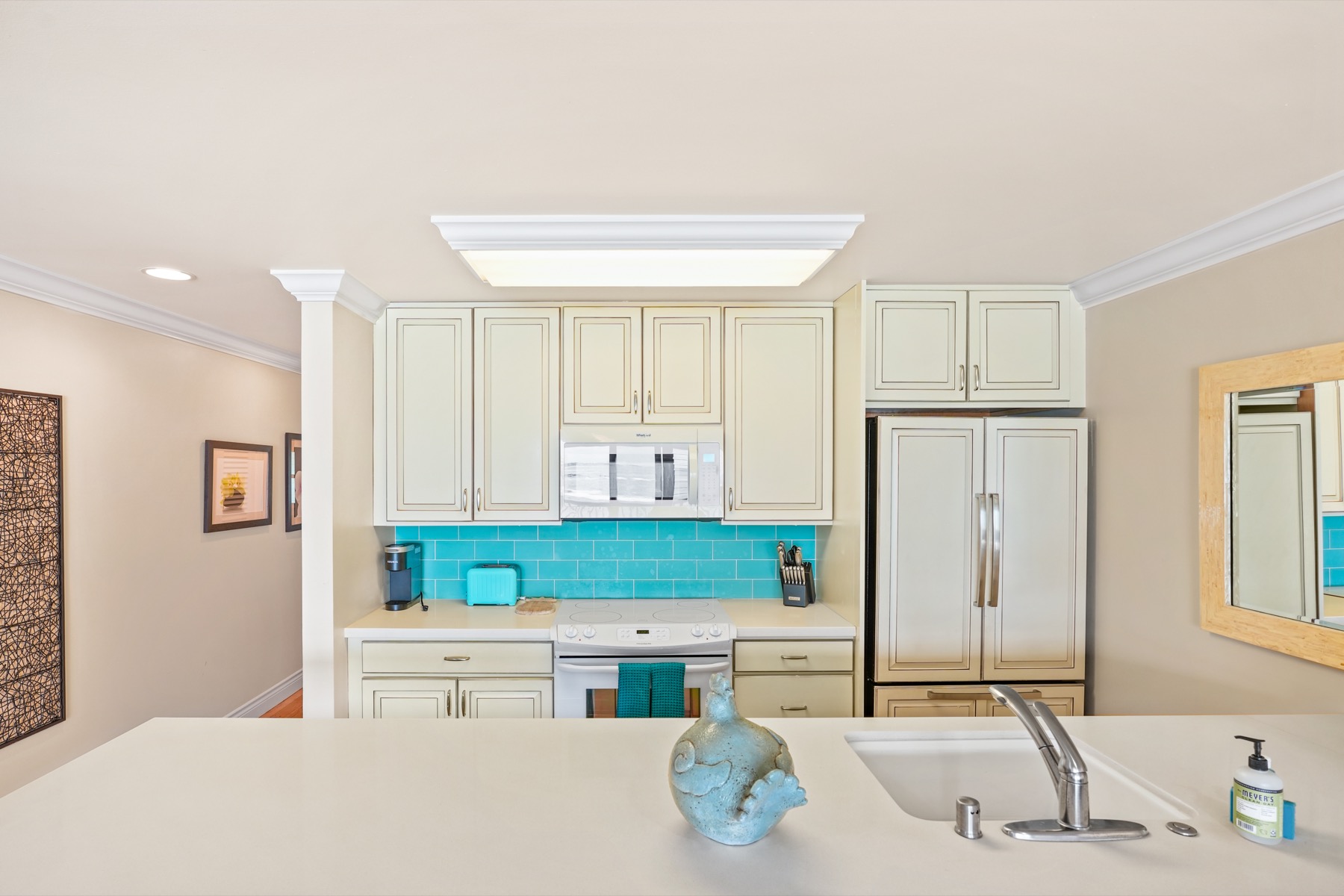 320 Papaloa Road, Unit 308 Kapaa, HI 96746 - Photo 12 of 26 a kitchen with kitchen island a stove a sink and a refrigerator
