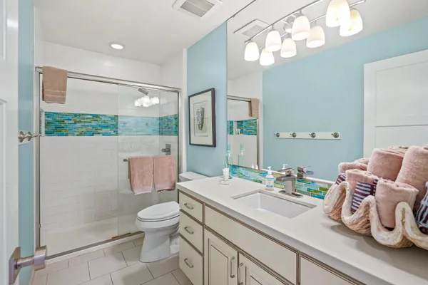 a bathroom with a granite countertop sink a toilet and mirror