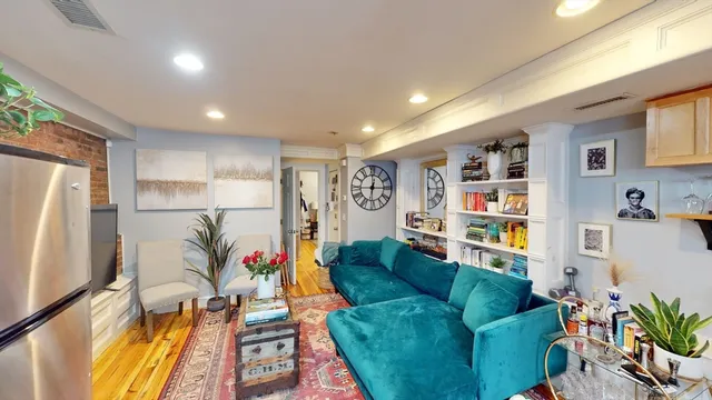a living room with furniture cabinets and a large window