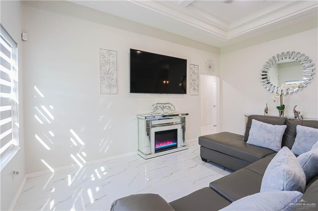 823 Whitewing Street Alamo, TX 78516 - Photo 3 of 15 a living room with furniture a fireplace and a flat screen tv