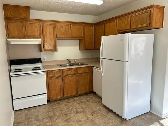 a kitchen with cabinets a refrigerator and a sink